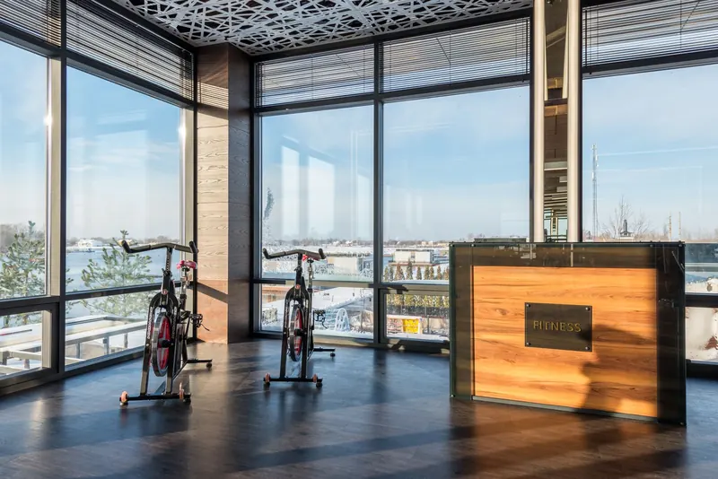 Bicicletas de spinning junto a los ventanales de un gimnasio
