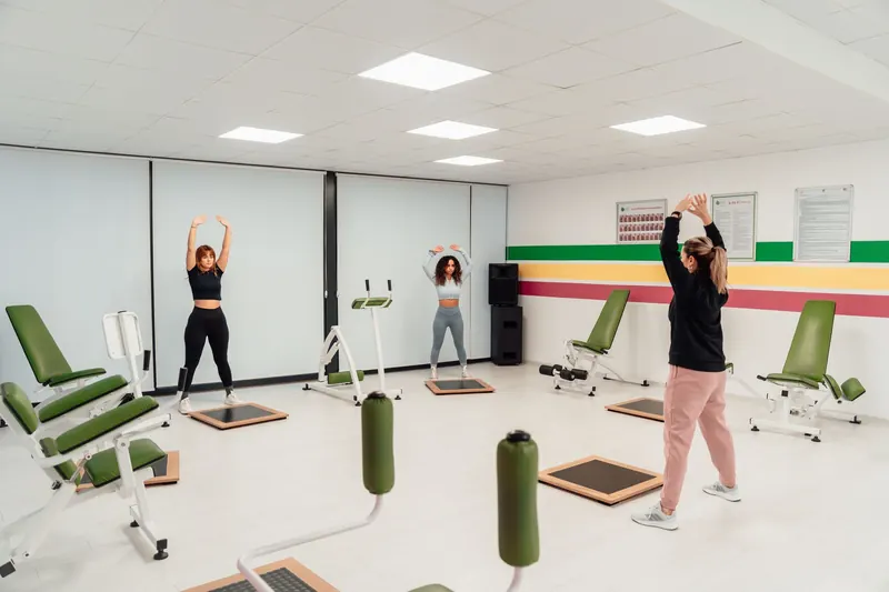 Clase dirigida en grupo dentro de un gimnasio luminoso